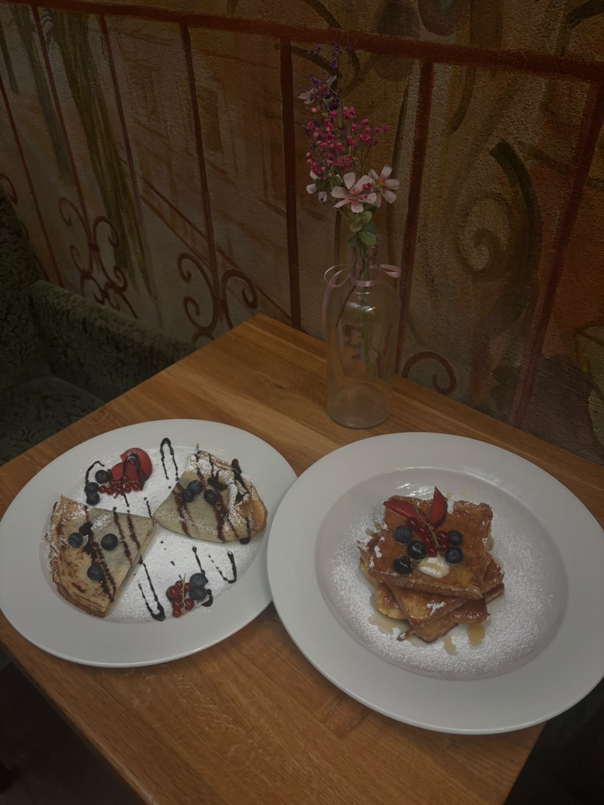 Breakfast plates — crêpes and French toast dusted with icing sugar, berries and syrup