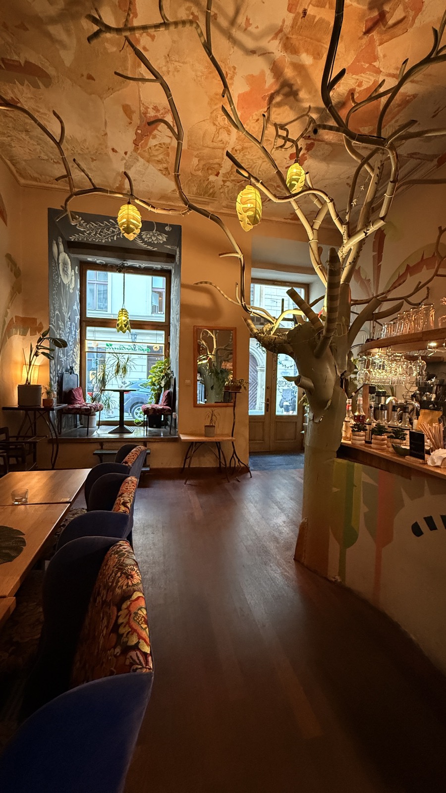 The tree room by day — sculptural tree, bar and tall Old-Town windows