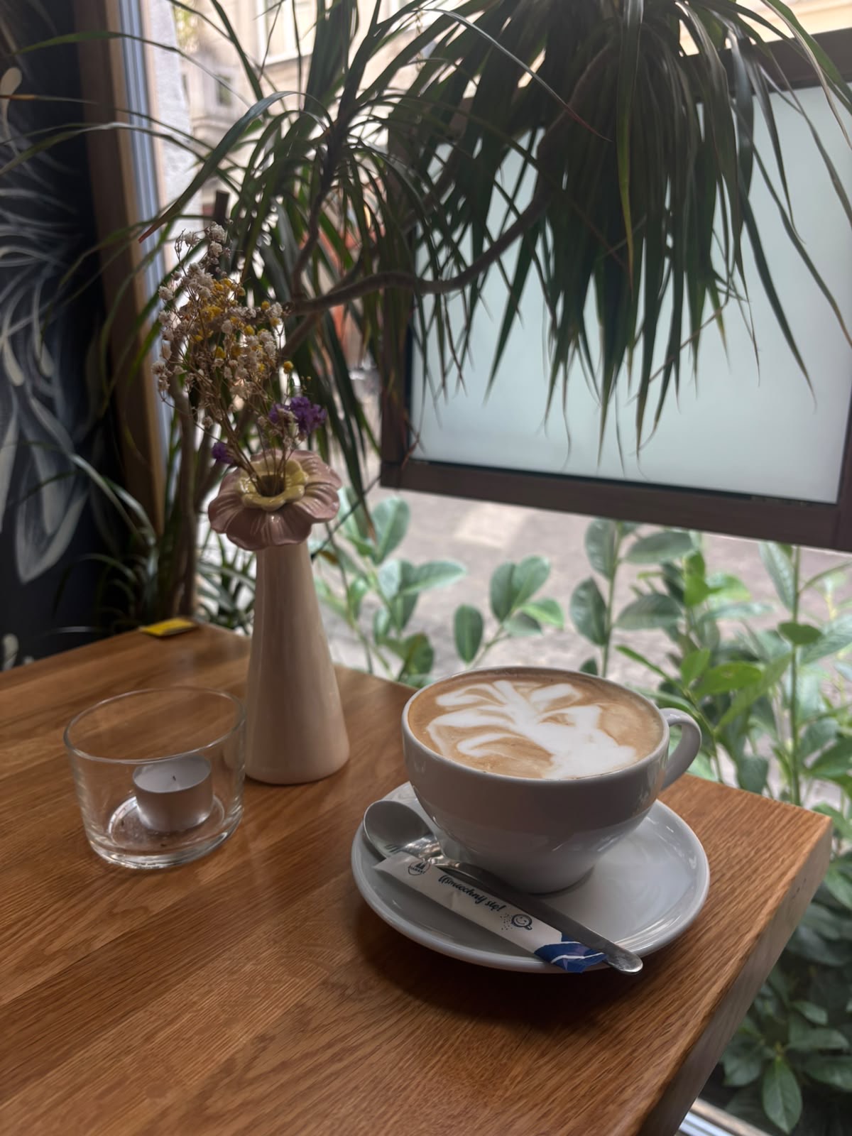 Cappuccino with latte art beside a slice of chocolate cake